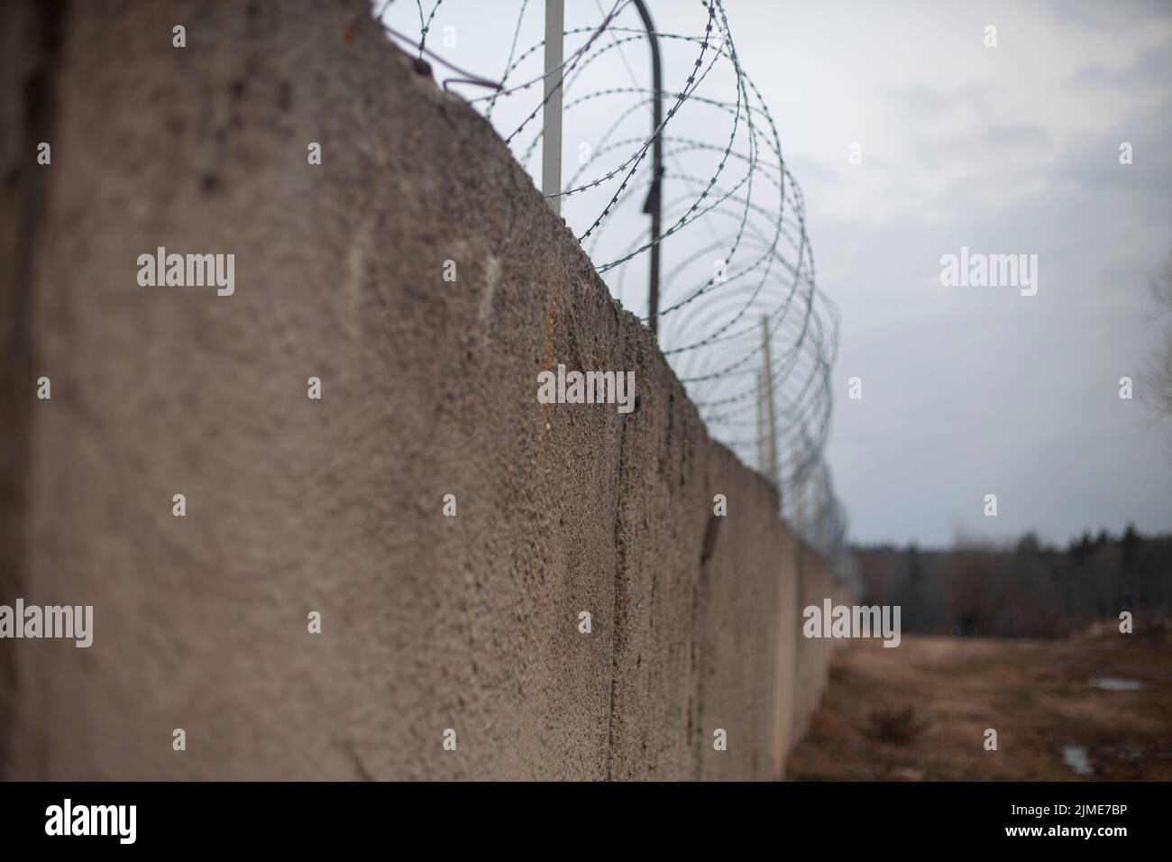 Fence with barbed wire. Fencing around the territory. Stock Photo