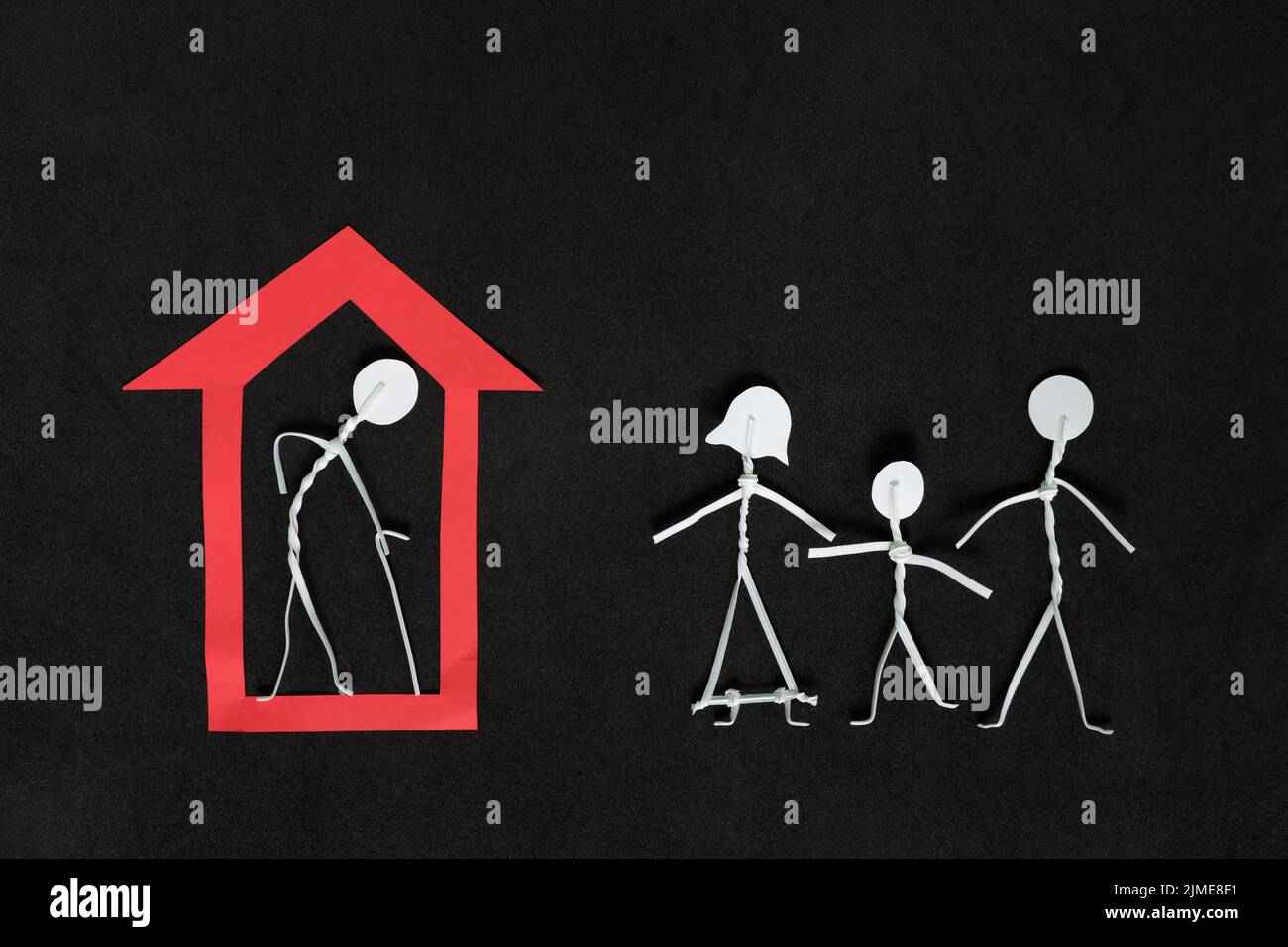 Seniors or old people feeling of isolation, social exclusion and loneliness concept. Elderly man stick figure alone inside a house in dark black Stock Photo