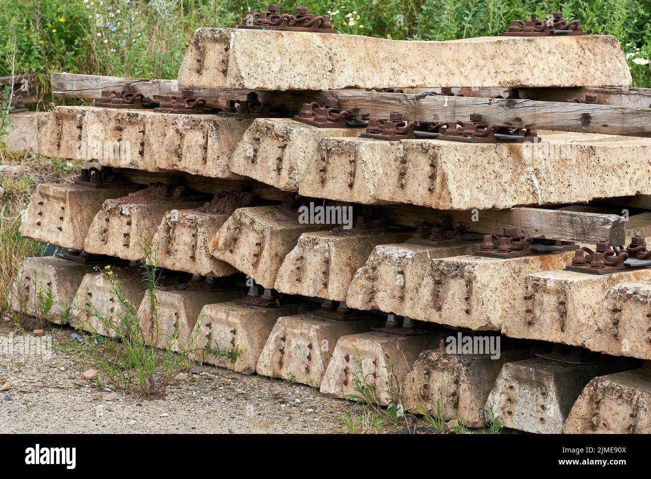 Old no longer used overgrown and discarded railroad sleepers in a storage yard Stock Photo