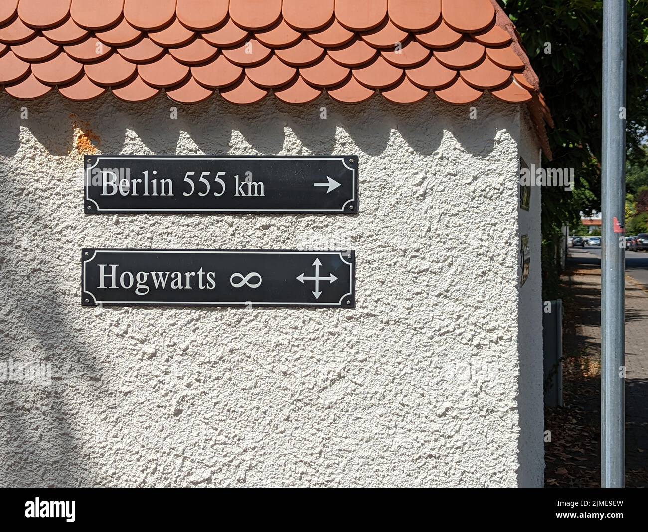 A building wall with signposts showing directions to Berlin and