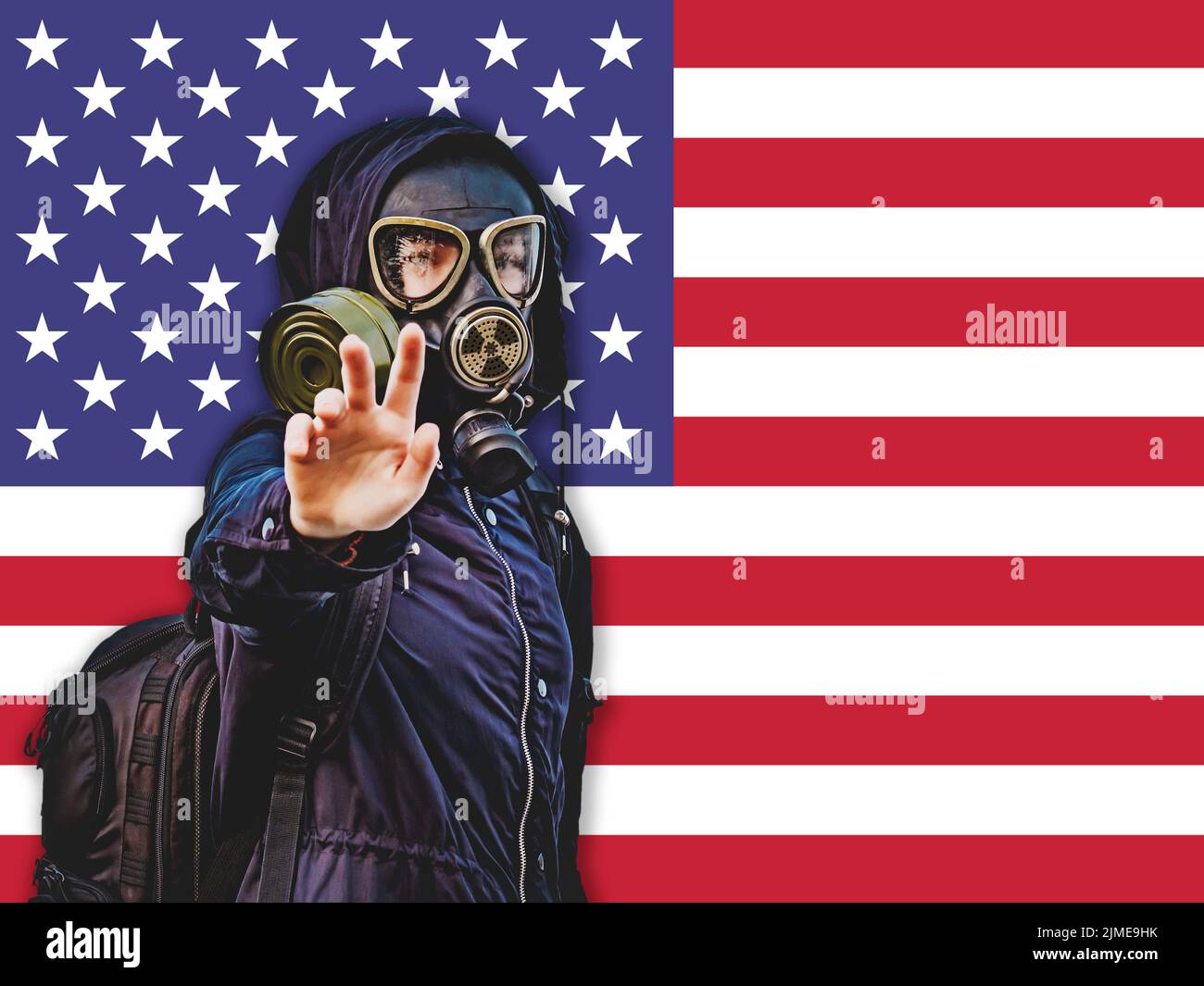 Girl in a black gas mask against the background of the flag of the United States Stock Photo