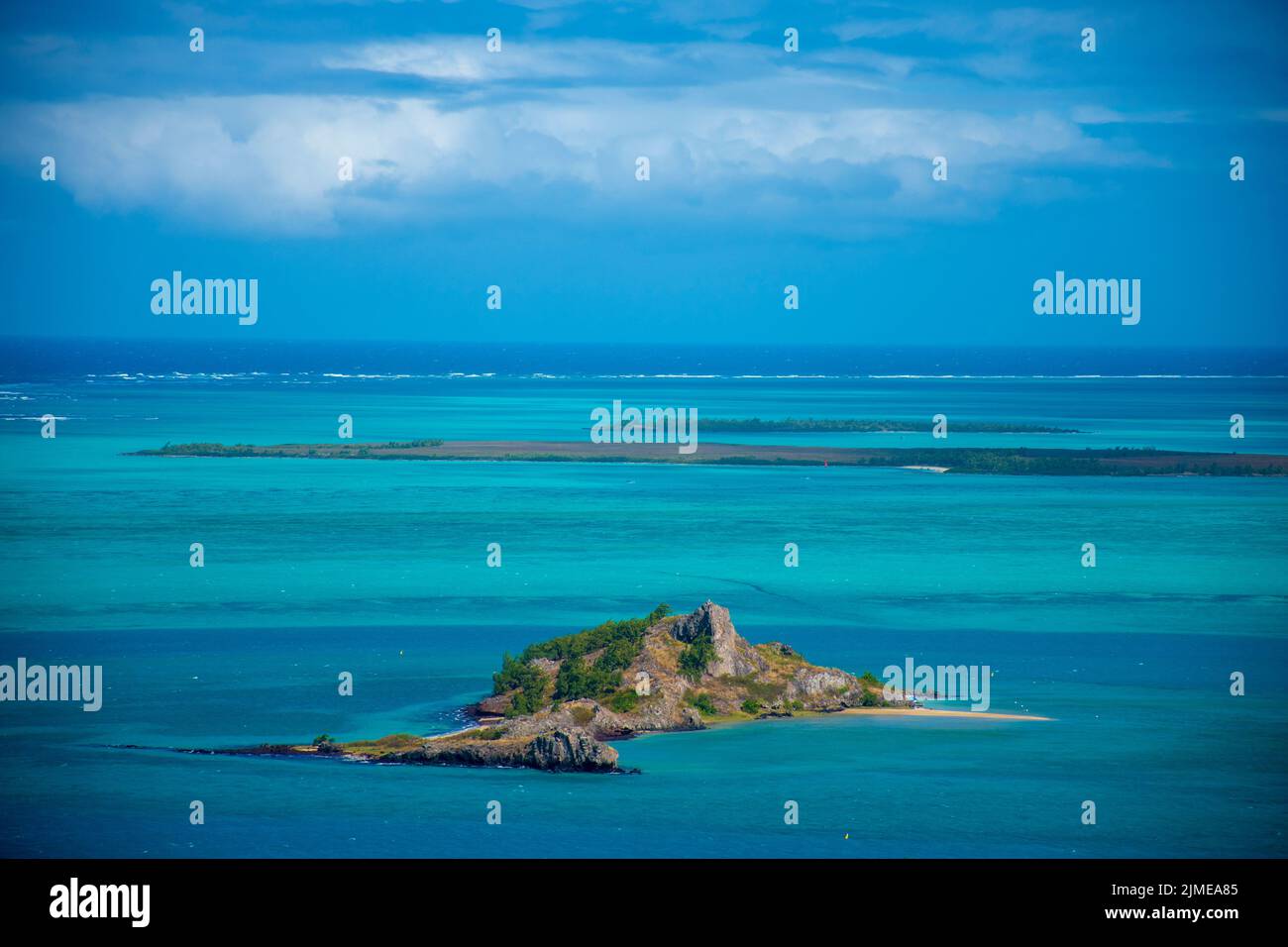 The aerial view of a small island in the blue ocean under the blue ...