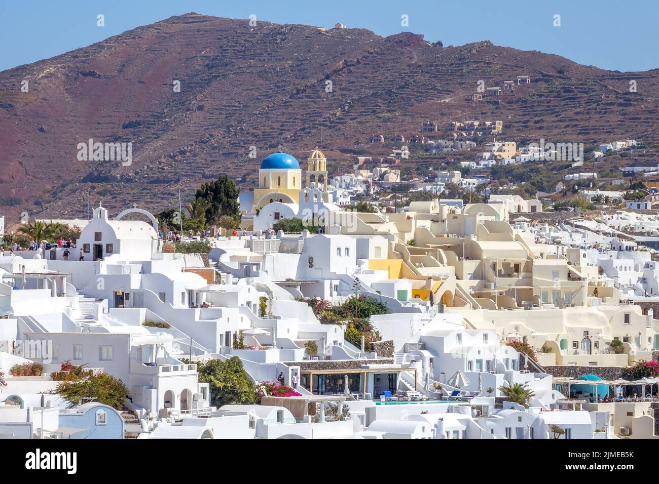 White Buildings on Santorini and Mountain on a Sunny Day Stock Photo