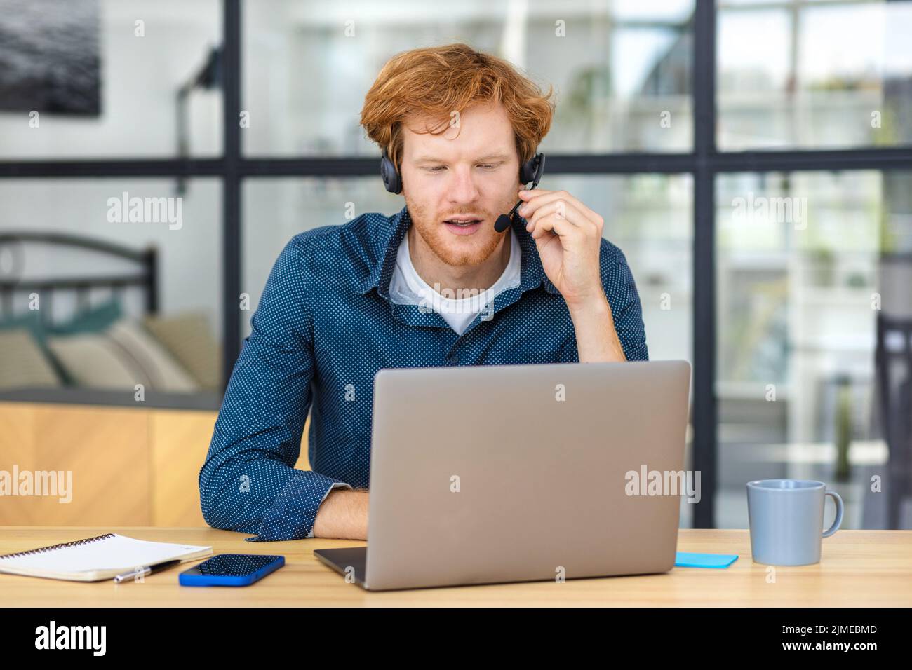 Man customer support call center operator or receptionist in headset consulting client Stock Photo