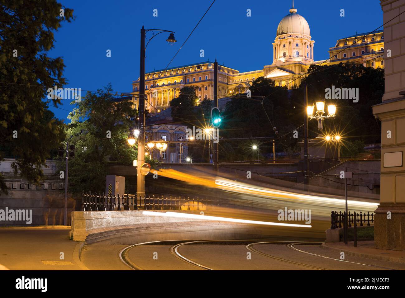 Light trail on a tram turn against Royal Palace Building at night Stock Photo