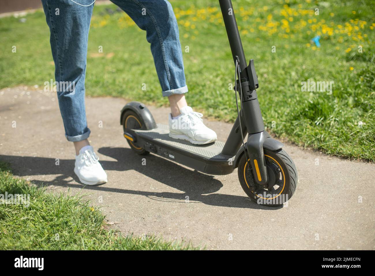 Guy on electric scooter. Man put his foot on platform of scooter