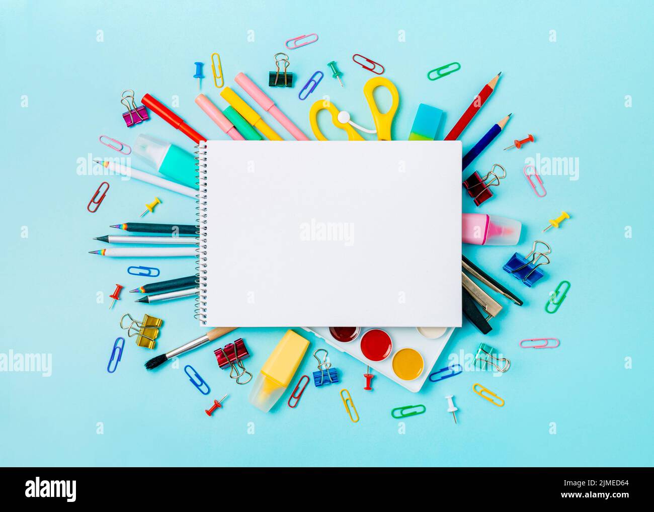 School supplies and empty notebook on blue bckg Stock Photo