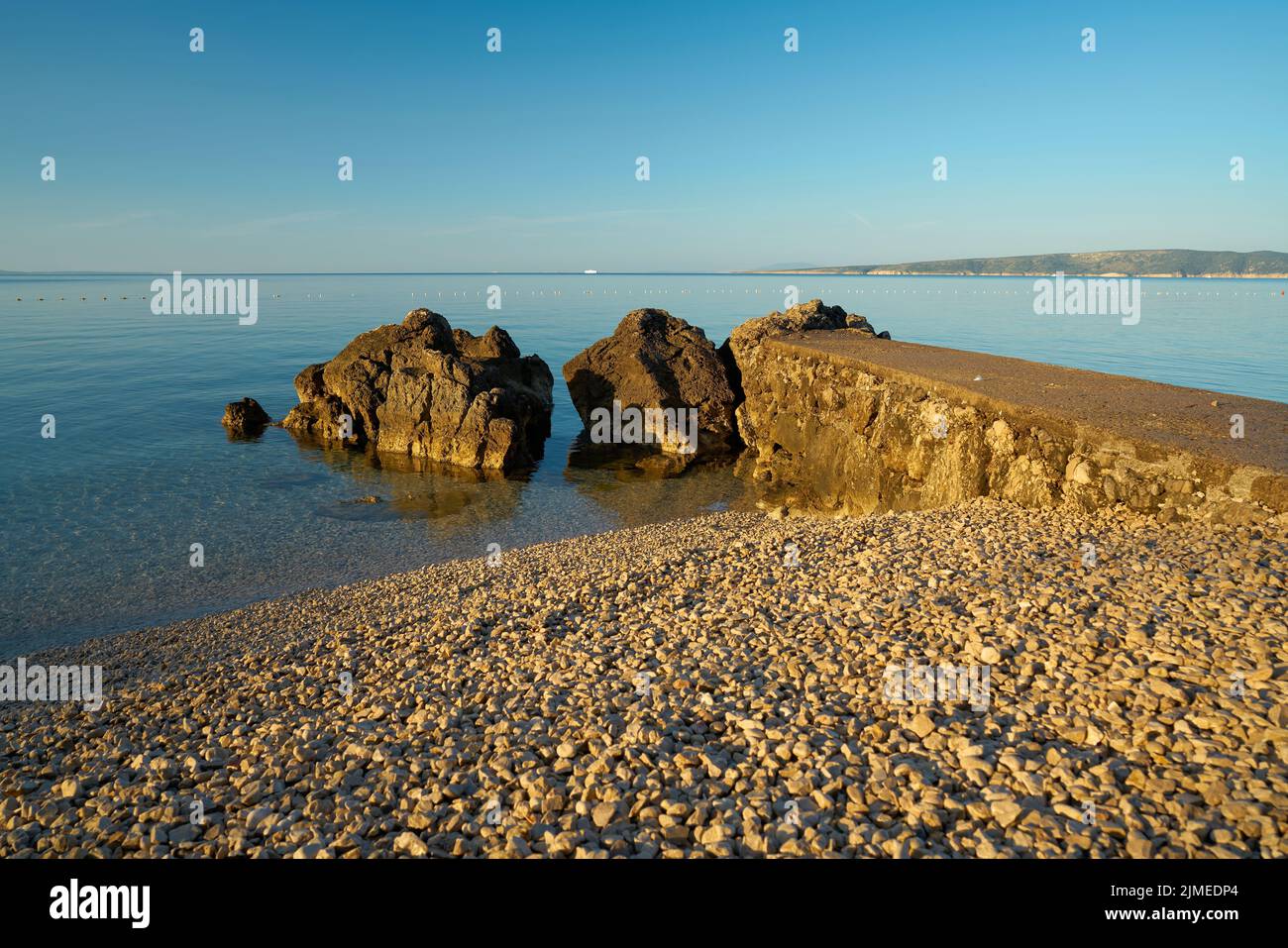 Bathing place with piled up gravel on the actually rocky coast of Krk in Croatia Stock Photo