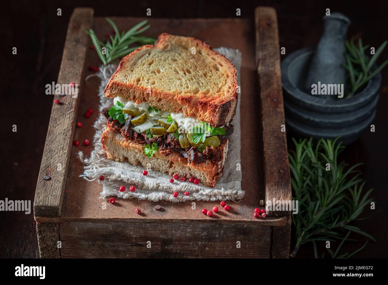Delicious and homemade sandwich with gherkin, shredded beef and bbq sauce. American street food