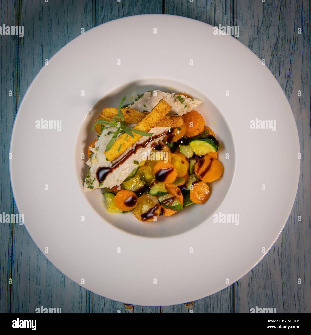 Fish recipe, fillet of sea bass with small vegetables Stock Photo - Alamy