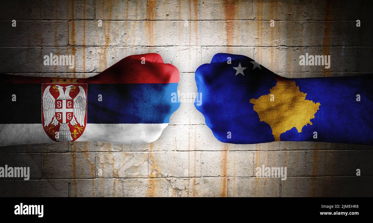 Fists painted with a flag of Serbia on the left and a flag of Kosovo on the right. Stock Photo