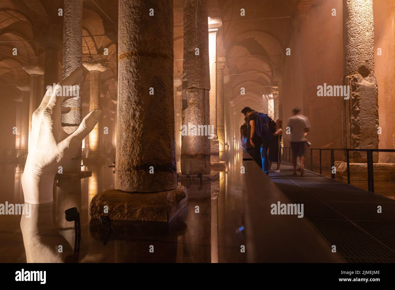 Tourists visiting the Basilica Cistern or Yerebatan Sarnici in Istanbul. Noise and grain included. Selective focus. Motion blur on people. Istanbul Tu Stock Photo