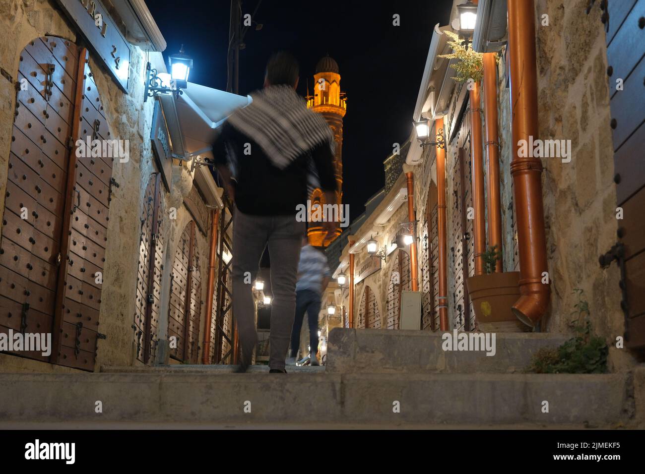 Selective focus street view in ancient Mardin at night, ancient mosque background from narrow streets of city . 07.11.2022. Mardin. Turkey. Stock Photo