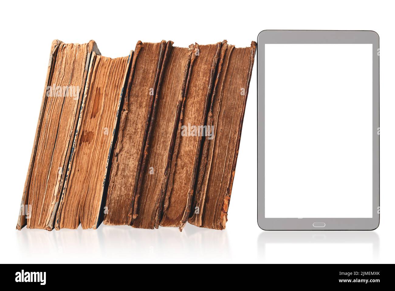 Stack of old hardcover brown books and modern digital tablet with blank white screen together isolated on white with reflection. Old vs new. Mockup Stock Photo