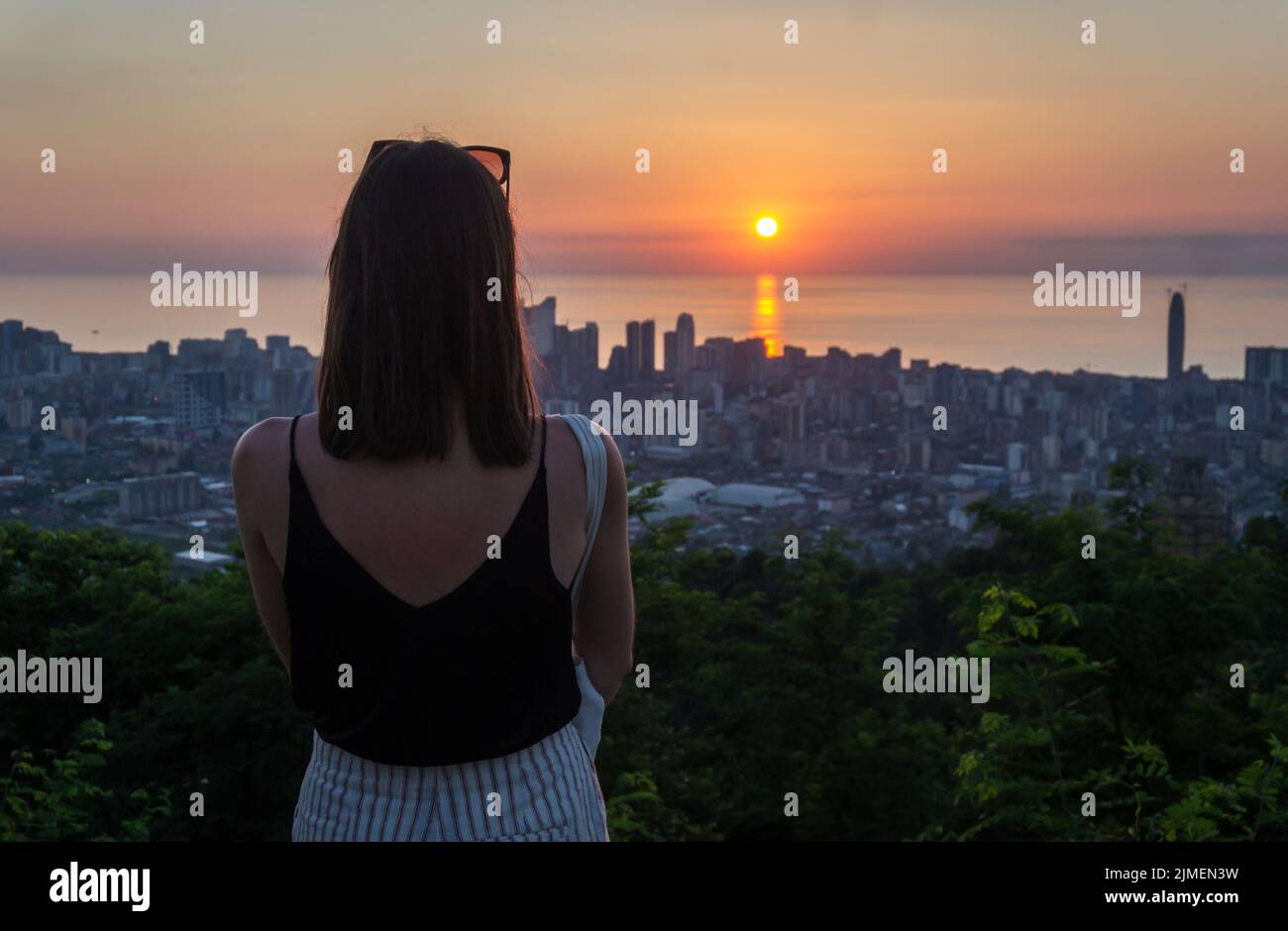 Batumi, Georgia top view at sunset. Young unrecognizable woman overlooking Batumi city from the observation platform Stock Photo