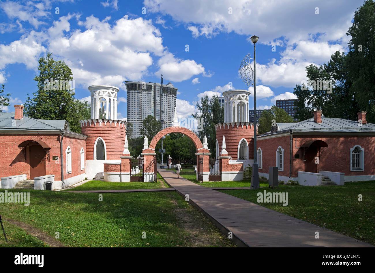 Entrance gates in the park of the old manor against the background of a modern building. Stock Photo
