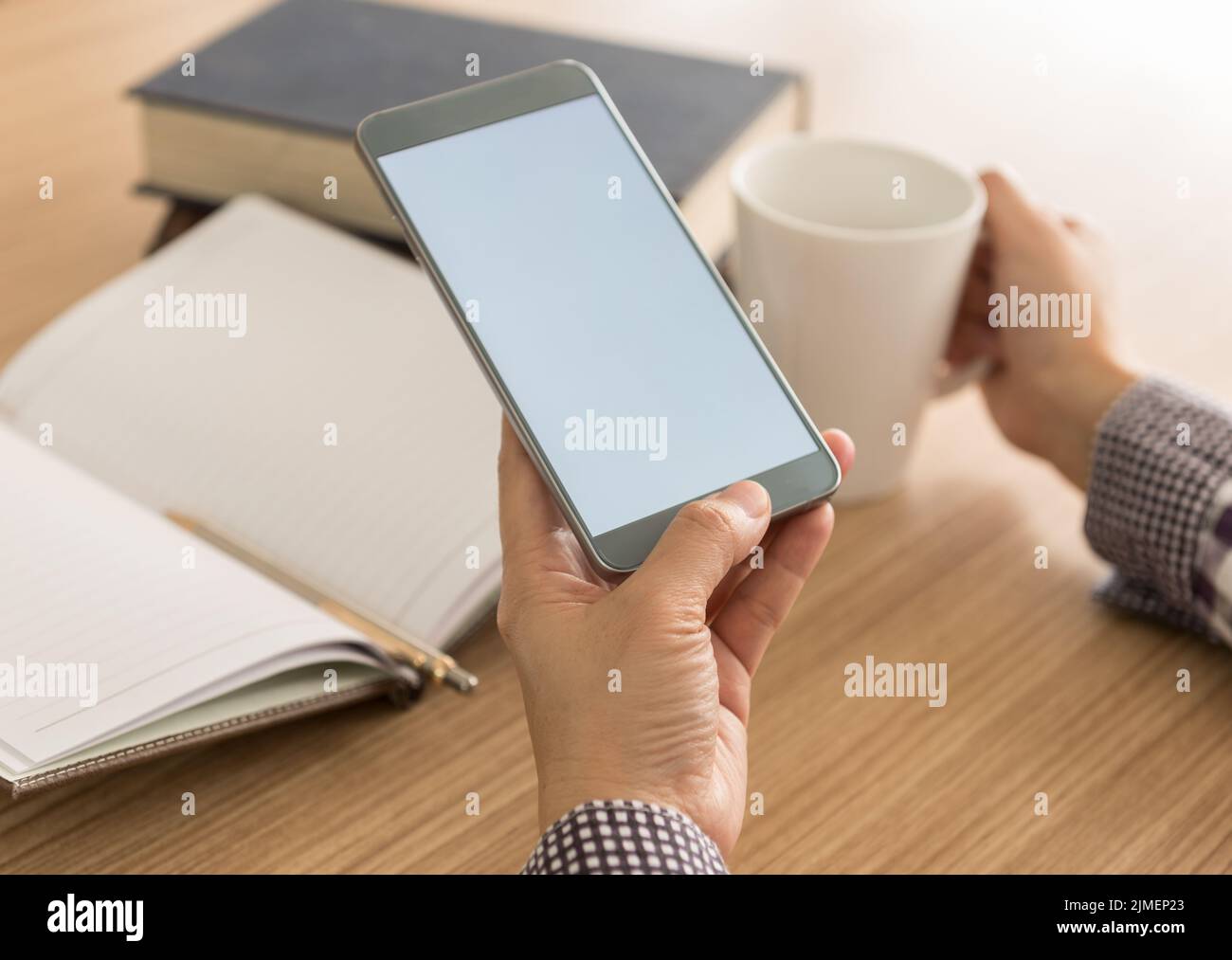 women using mobile phone in cafe. sofe focus. blank screen for your advertising. Stock Photo