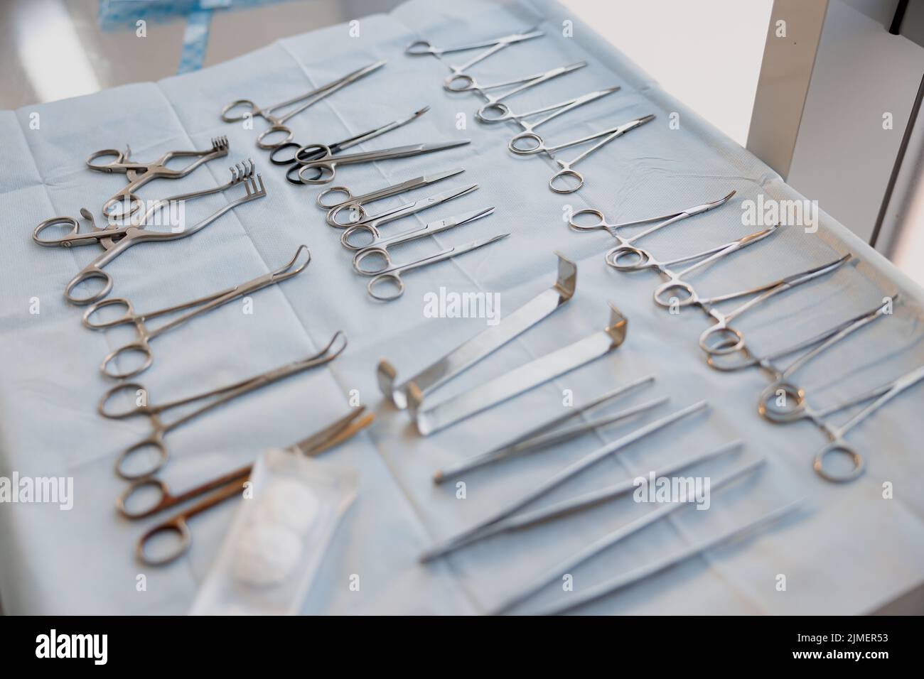 Surgical instruments and tools including scalpels forceps and tweezers arranged on table for surgery Stock Photo