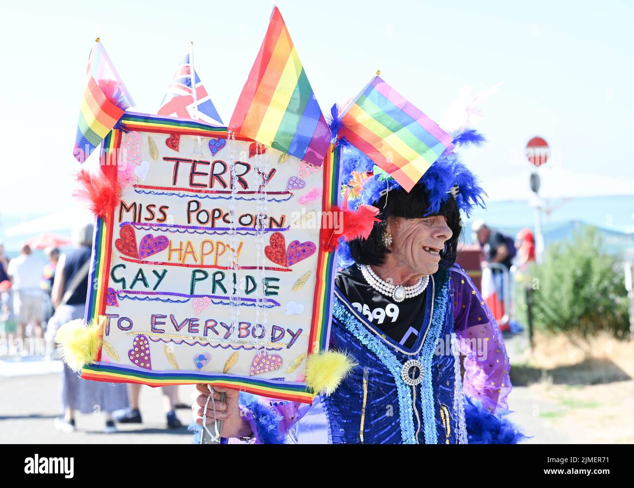 Brighton UK 6th August 2022 - Terry known as miss Popcorn at the  Brighton and Hove Pride Parade on a beautiful hot sunny day. With good weather forecast large crowds are expected to attend the UK's biggest LGBTQ Pride festival in Brighton over the weekend : Credit Simon Dack / Alamy Live News Stock Photo