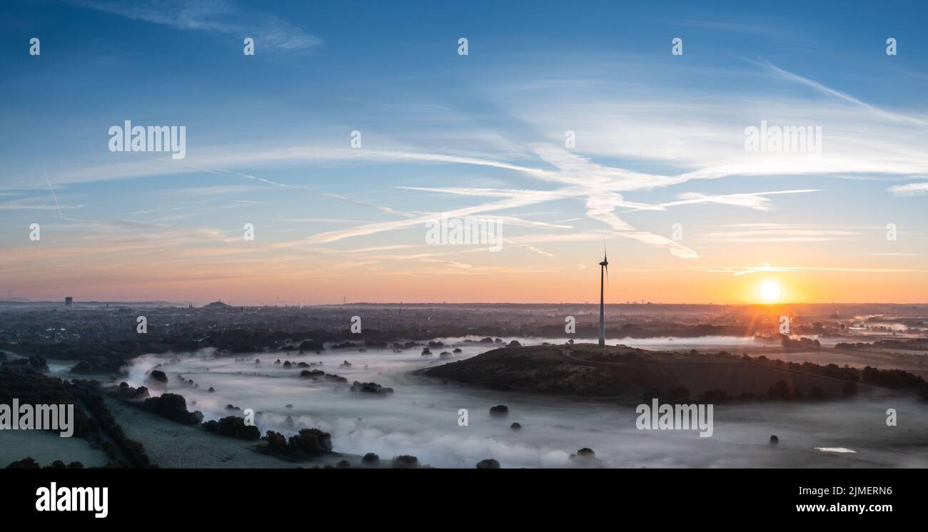Sunrise and the first rays of sunshine over the fog-covered Ruhr meadows in Duisburg, Germany Stock Photo