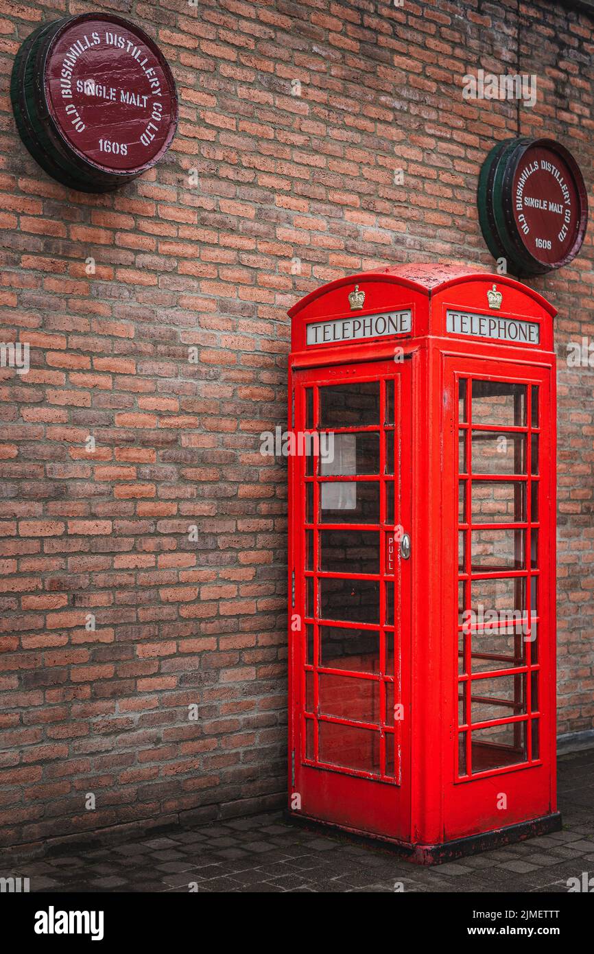 Traditional British public telephone booth with Bushmills whiskey barrels above Stock Photo