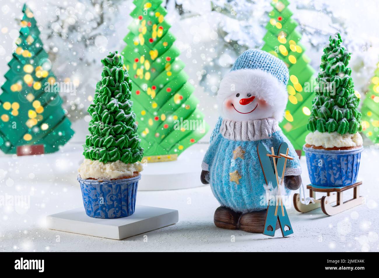 Christmas card with a Snowman and cupcakes. Stock Photo