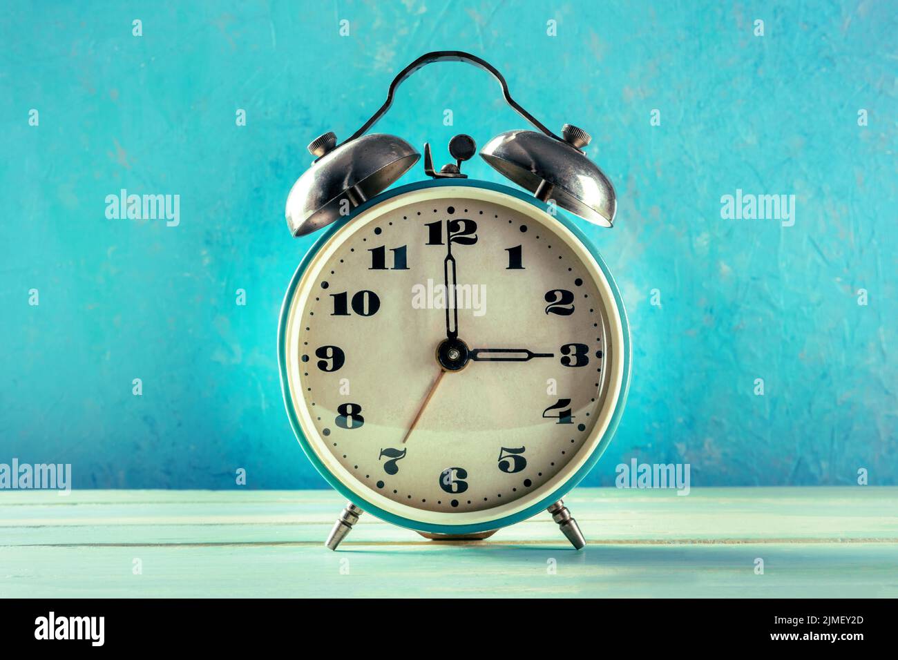 A vintage alarm clock on a vibrant blue background Stock Photo - Alamy