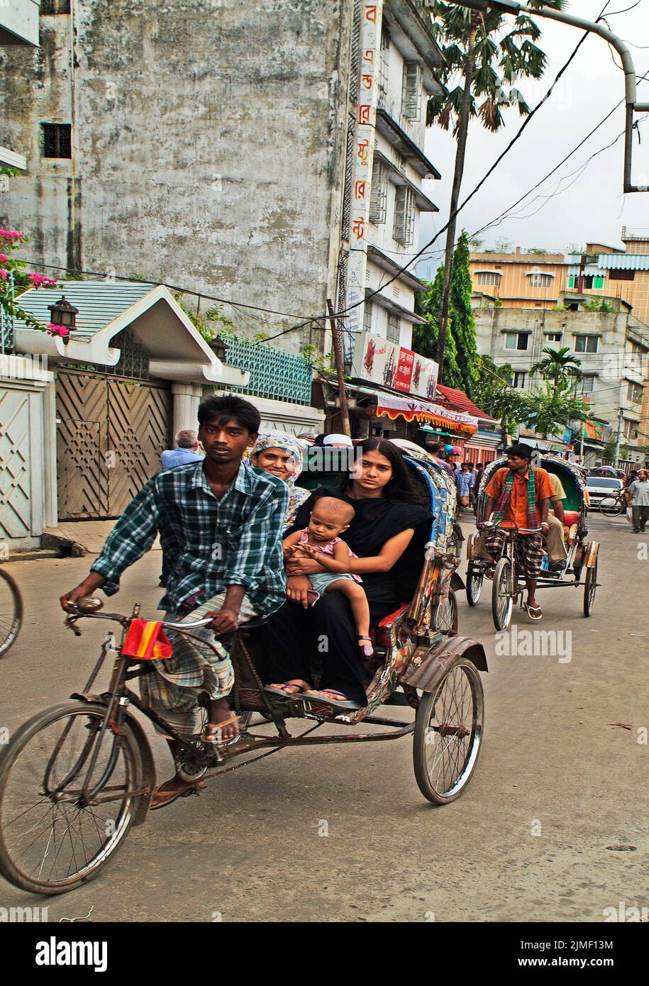 Dhaka, Bangladesh - September 17, 2007: Unidentified people in traditional cycle rickshaw, an usual mode of transport Stock Photo