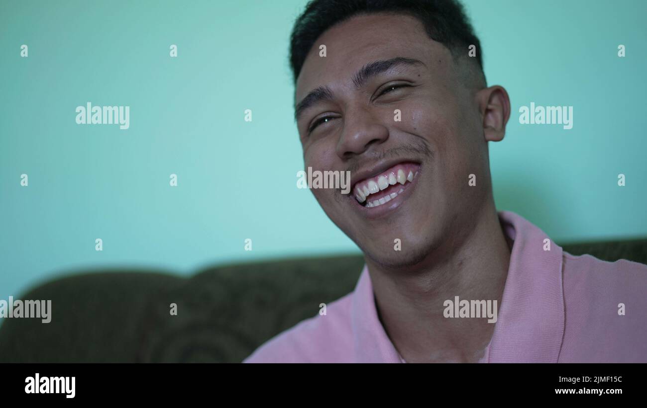 A hispanic young man laughing. Casual guy real life laugh and smile