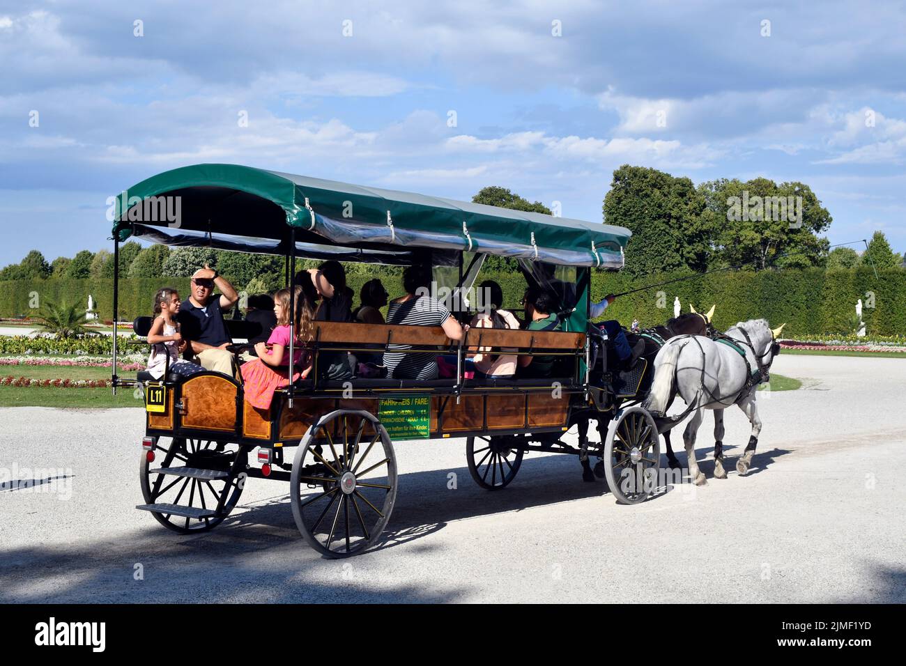 Vienna, Austria - August 01, 2022: Unidentified tourists in a horse-drawn carriage in Schoenbrunn Park- former residence of the Habsburg rulers and to Stock Photo