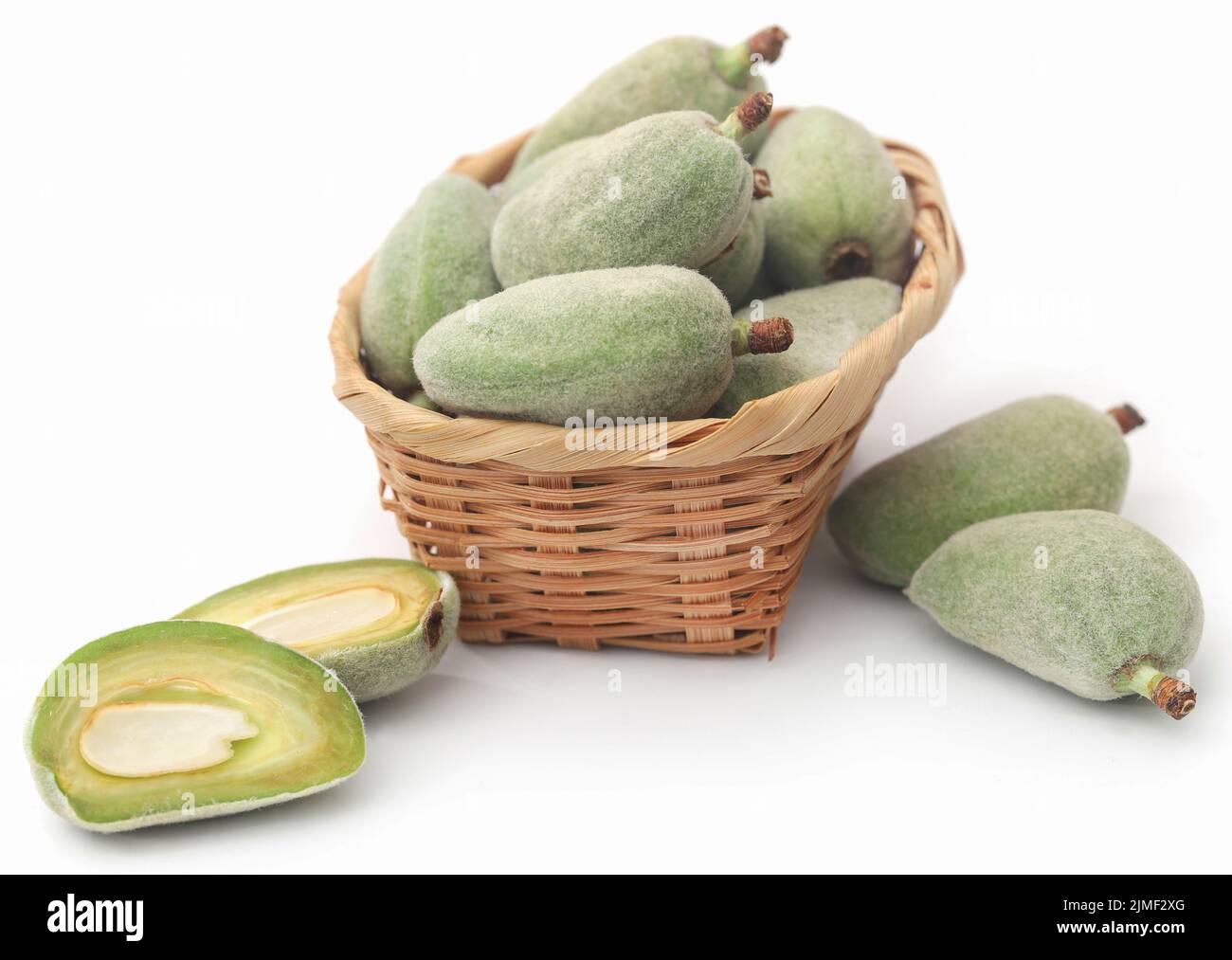 Green almond in basket over white background Stock Photo