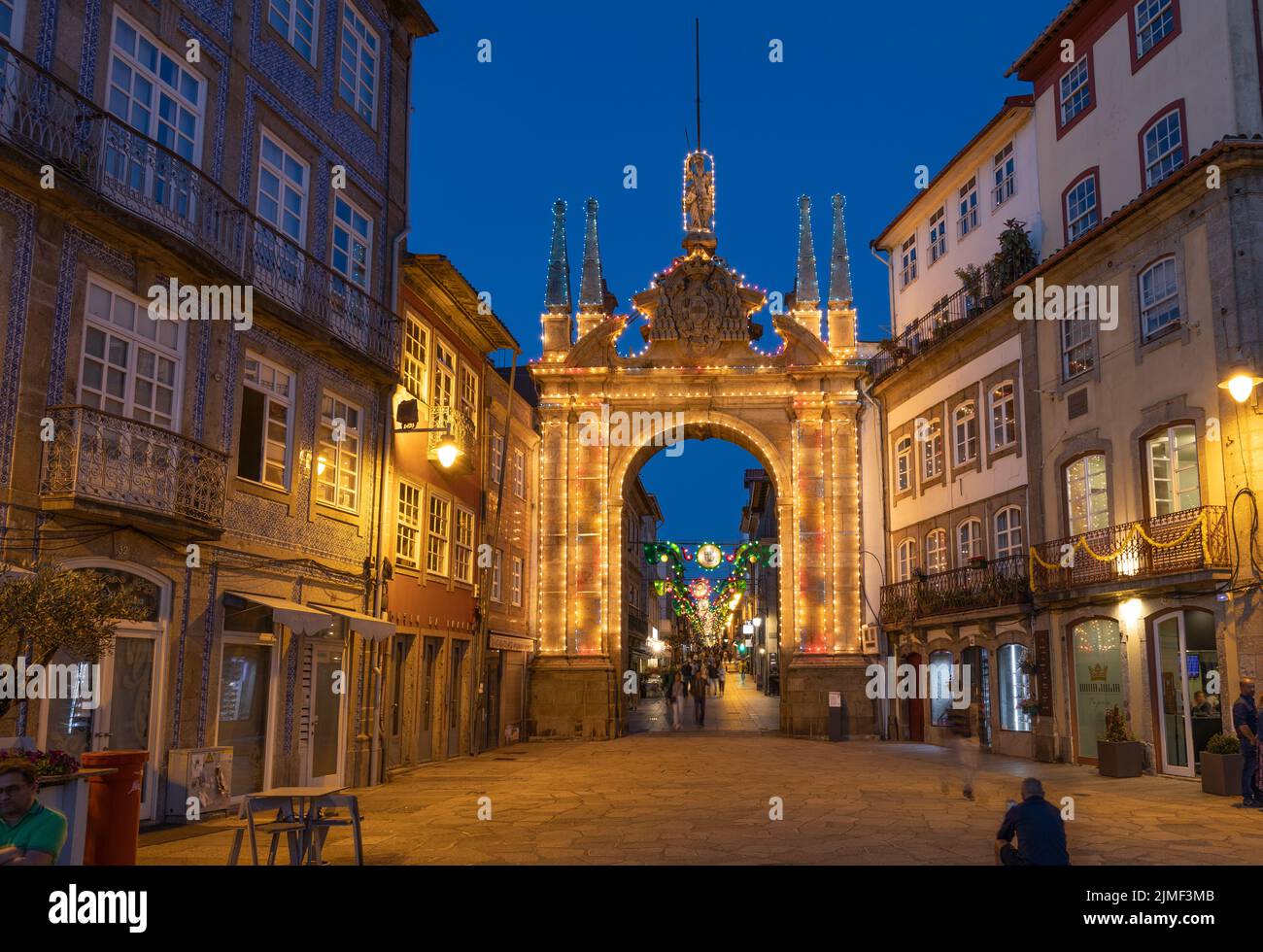 Braga, PORTUGAL - June 25, 2022: People around the illuminated  Arco da Porta Nova in Braga at twilight / blue hour. Stock Photo
