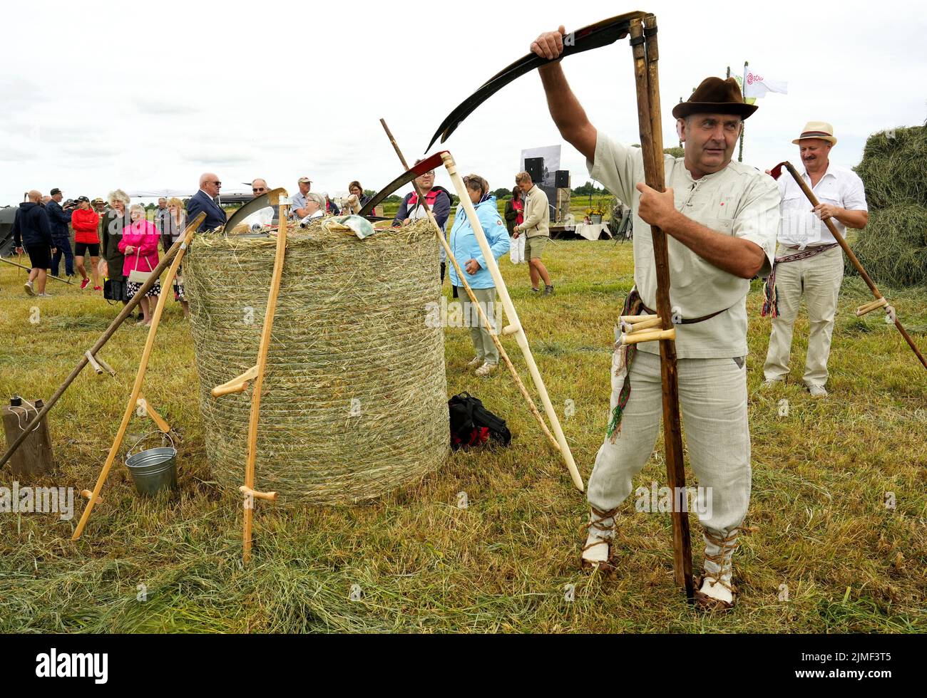 People attend Lithuanian mowing championship to cut down grass using scythes in Rupkalviai, Lithuania  August 6, 2022. REUTERS/Ints Kalnins Stock Photo