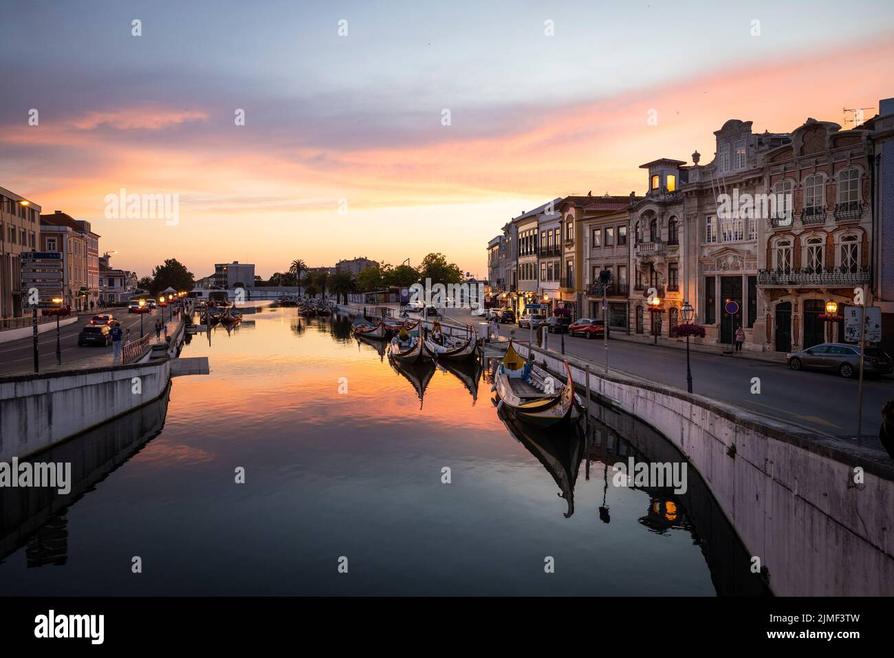 Aveiro, PORTUGAL - July 5, 2022: Boats at the Moliceiros Pier in Aveiro at blue hour. People on the pier and in the boats. Aveiro is called Portugals Stock Photo