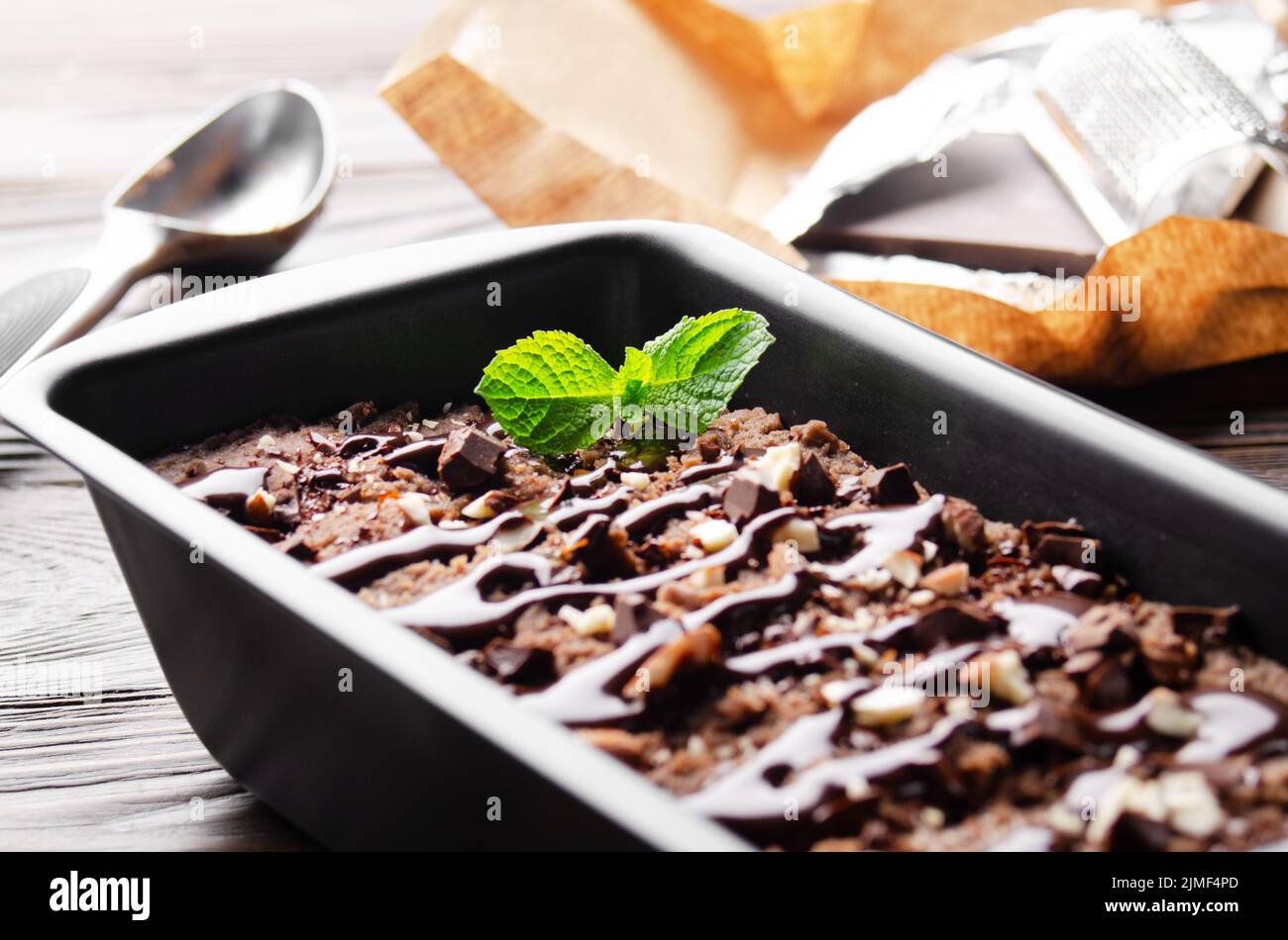 Chocolate icecream in metal tray with mint leaf and almond nuts Stock Photo