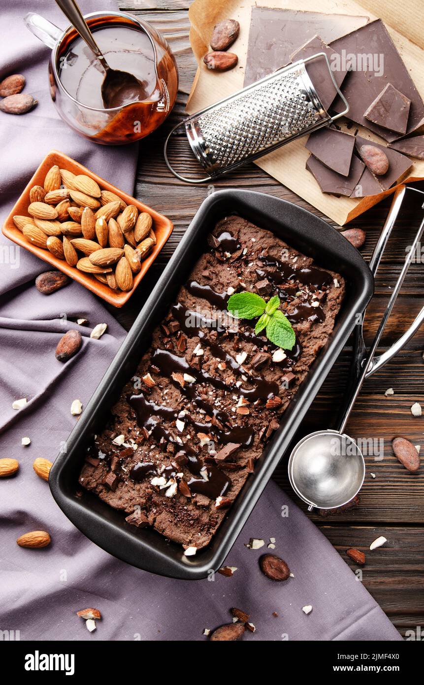 Flat lay view at chocolate icecream in metal tray with mint leaf and almond nuts Stock Photo
