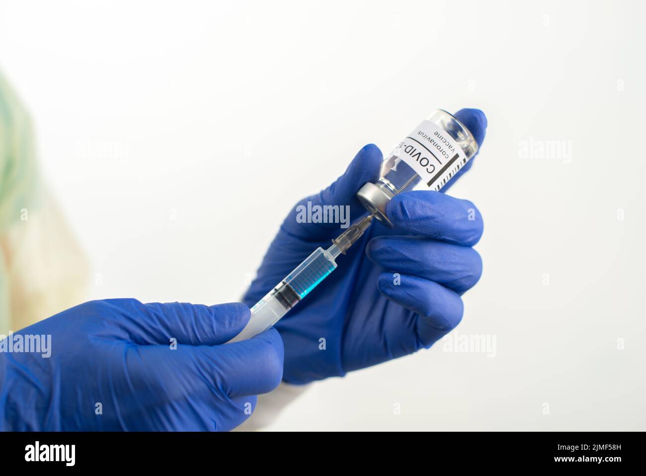 Doctor hands in safety gloves preparing syringe for coronavirus vaccine injection Stock Photo