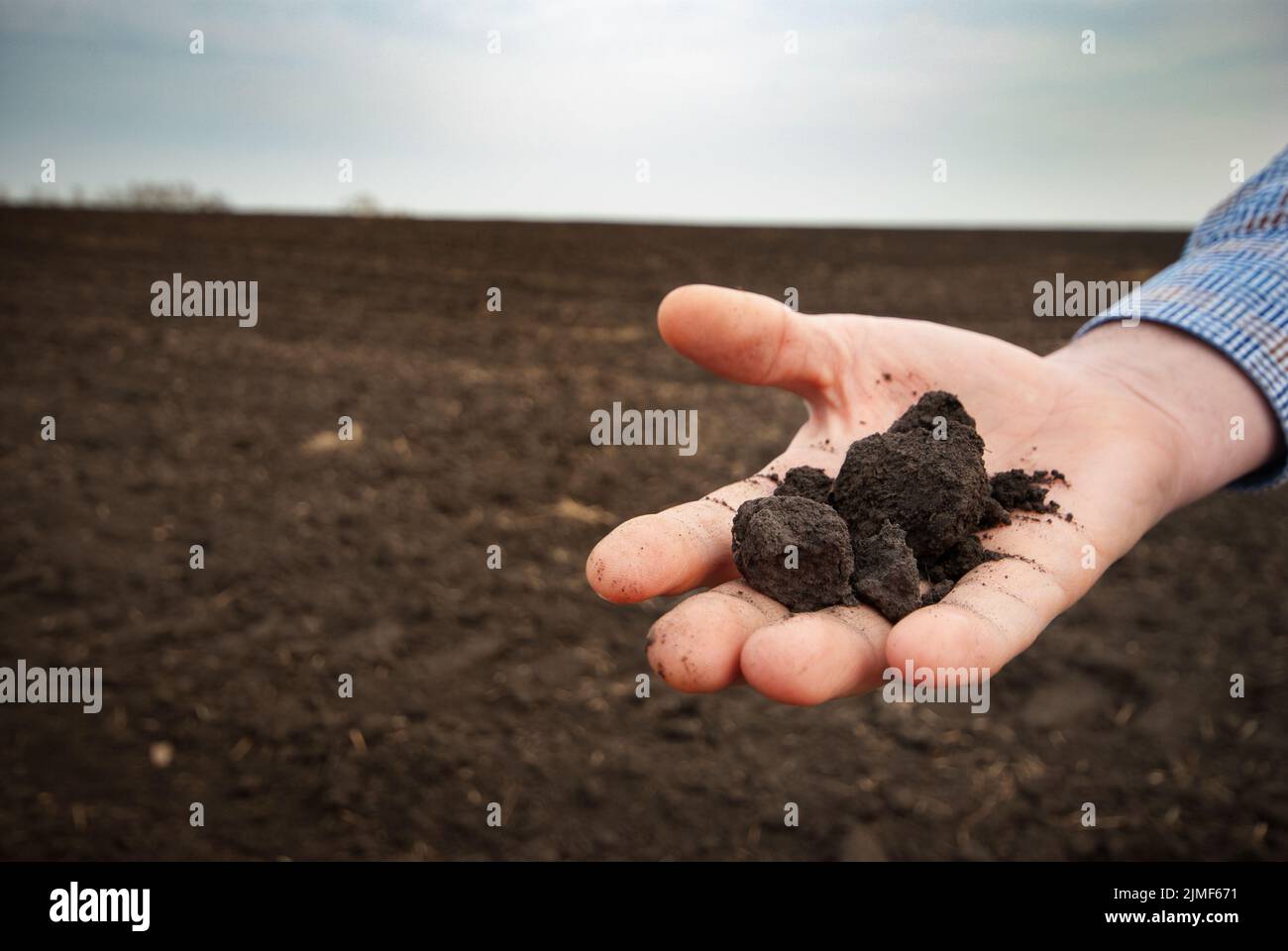 Closeup wideangle view at soil being held in farmer's hand Stock Photo
