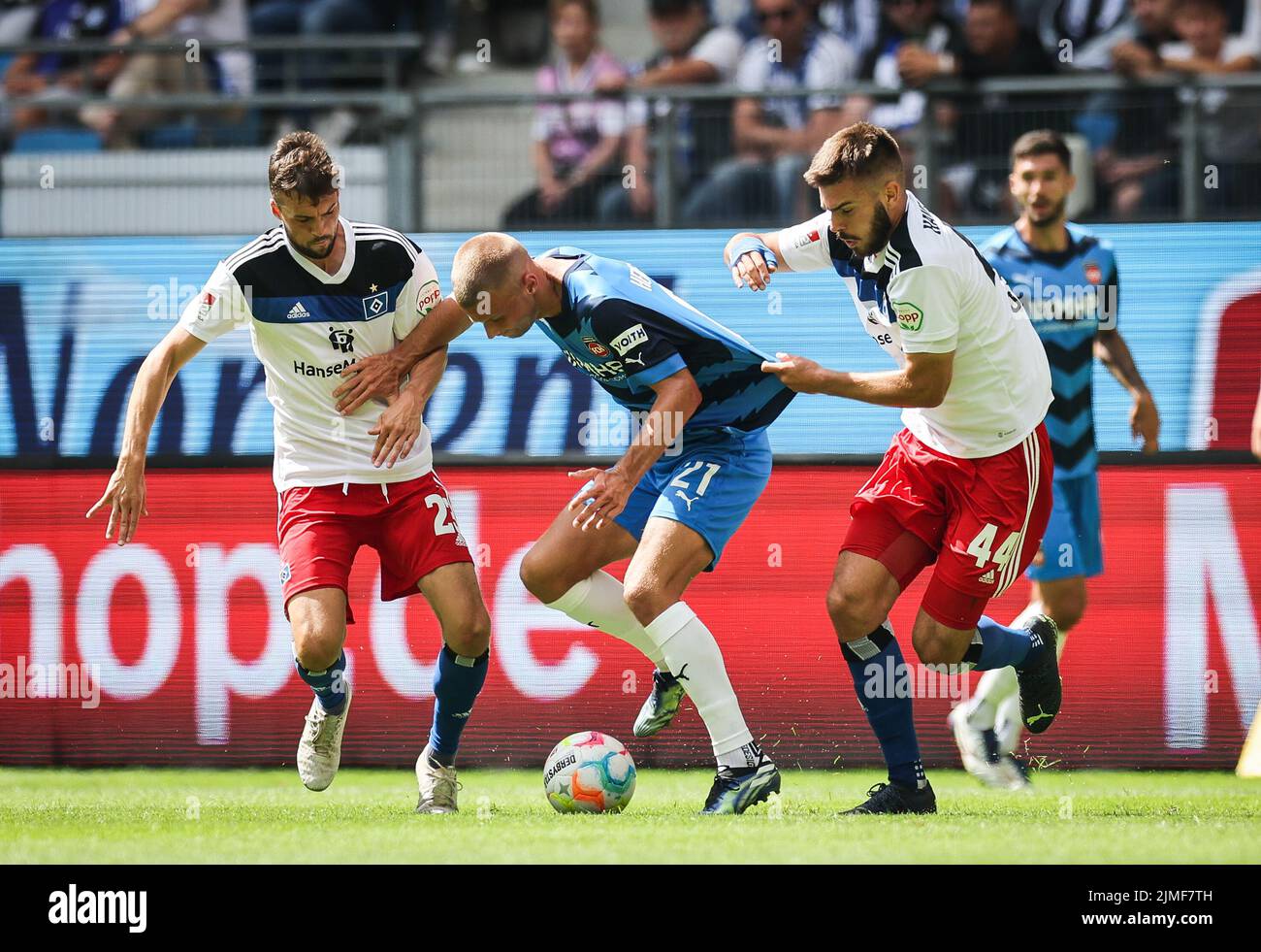Hamburg, Germany. 06th Aug, 2022. Soccer: 2nd Bundesliga, Matchday 3, Hamburger SV - 1. FC Heidenheim at Volksparkstadion. Heidenheim's Adrian Beck (center) battles for the ball with Hamburg's Jonas Meffert (left) and Mario Vuskovic. Credit: Christian Charisius/dpa - IMPORTANT NOTE: In accordance with the requirements of the DFL Deutsche Fußball Liga and the DFB Deutscher Fußball-Bund, it is prohibited to use or have used photographs taken in the stadium and/or of the match in the form of sequence pictures and/or video-like photo series./dpa/Alamy Live News Stock Photo