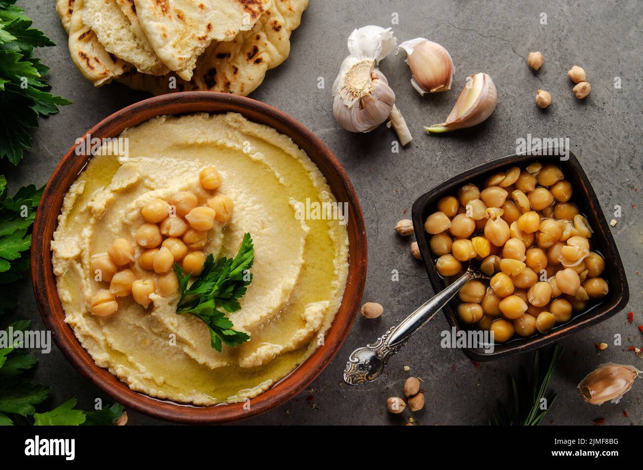 Hummus topped with chickpeas, olive oil and green coriander leaves on