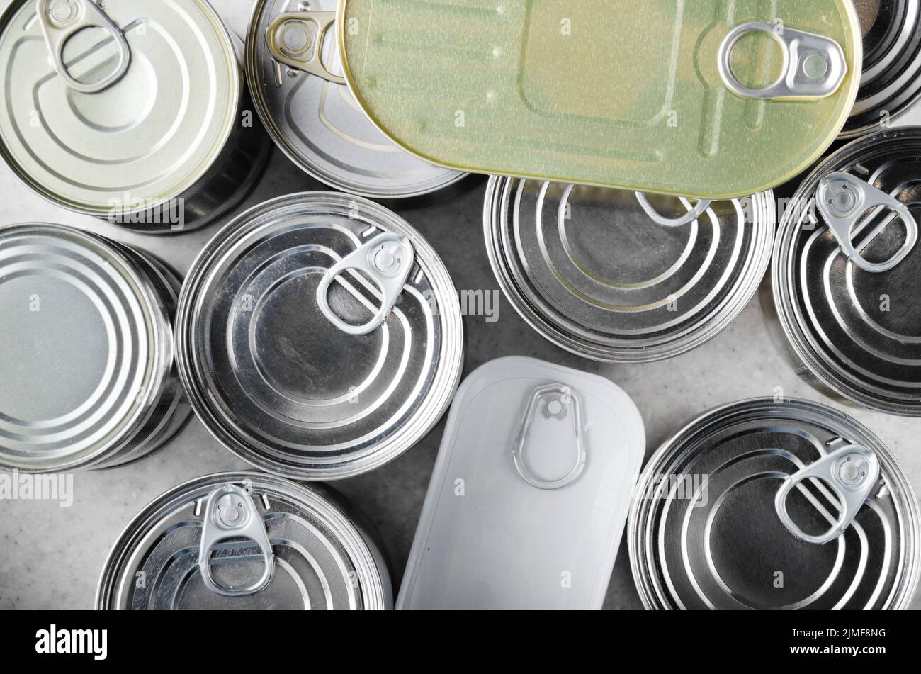Flat lay view at various canned foods in tin cans on kitchen table, non-perishable, long shelf life food for survival in emergen Stock Photo