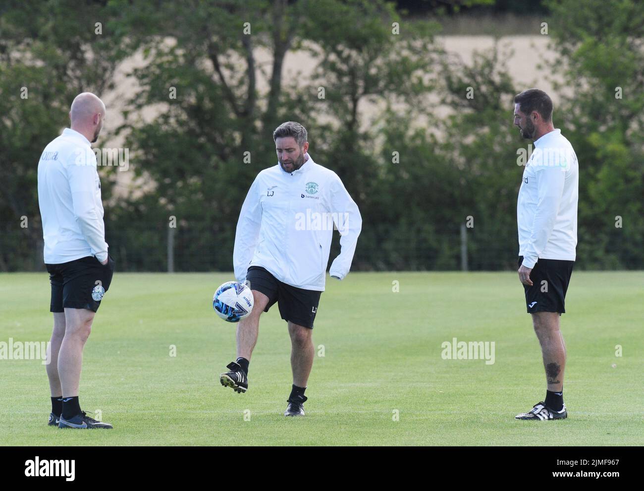 East Mains.Ormiston.Tranent.East Lothian.Scotland.UK.5th Aug 22 Hibernian FC Manager, Lee Johnson watched by coaches David Gray & Jamie McAllister(R) during training session for Cinch Premiership match v Hearts . Credit: eric mccowat/Alamy Live News Stock Photo