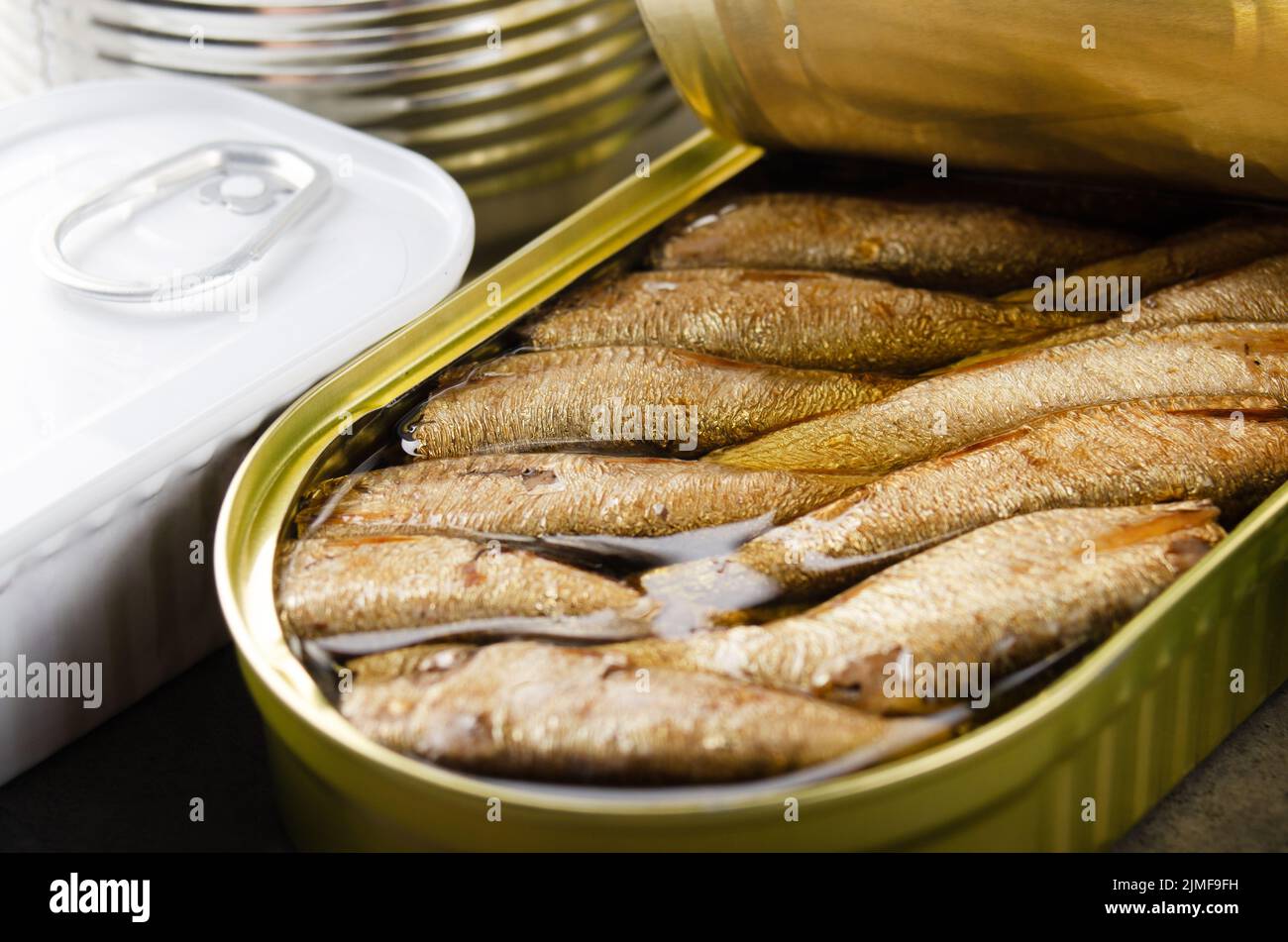 Canned smoked fish sprats in just opened tin can. Nonperishable food