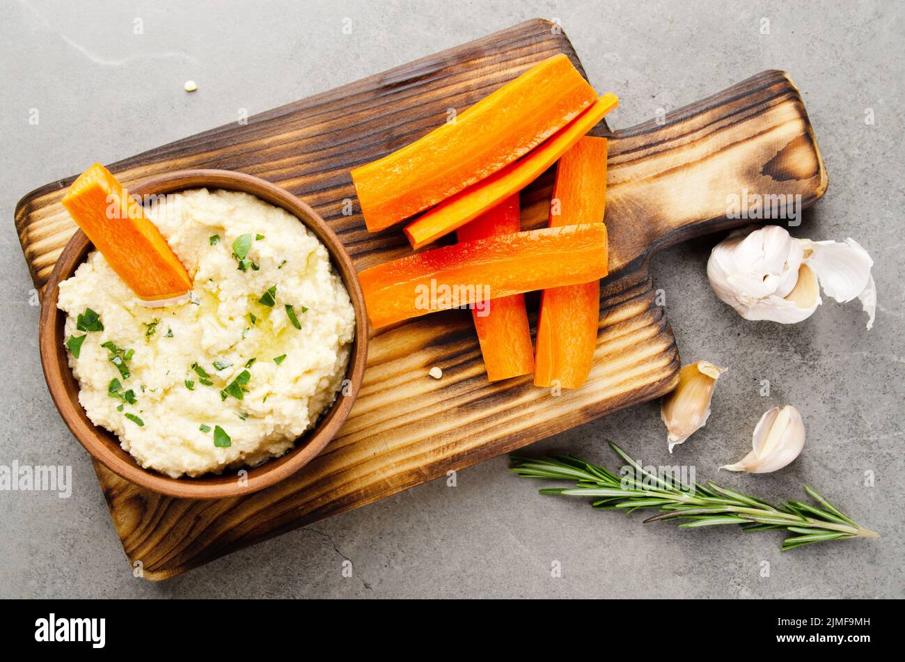 Flat lay view at vegetable Hummus dip dish topped with olive oil served with carrot slices Stock Photo