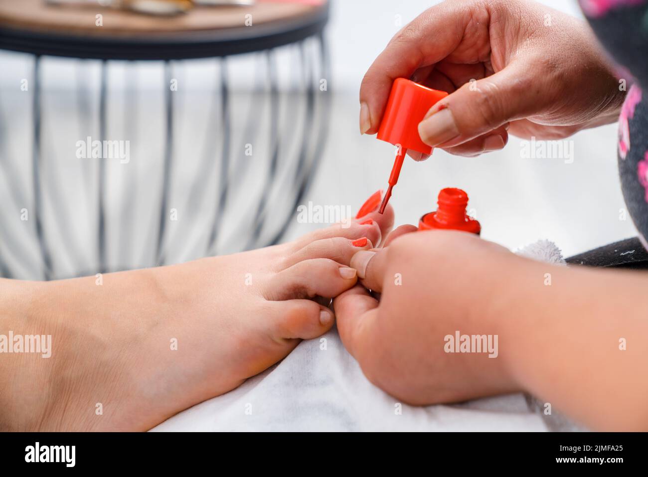 Close up photo of nail polishing. Woman get pedicure treatment in beauty salon. Beauty and cosmetic concept. High quality photo. Stock Photo
