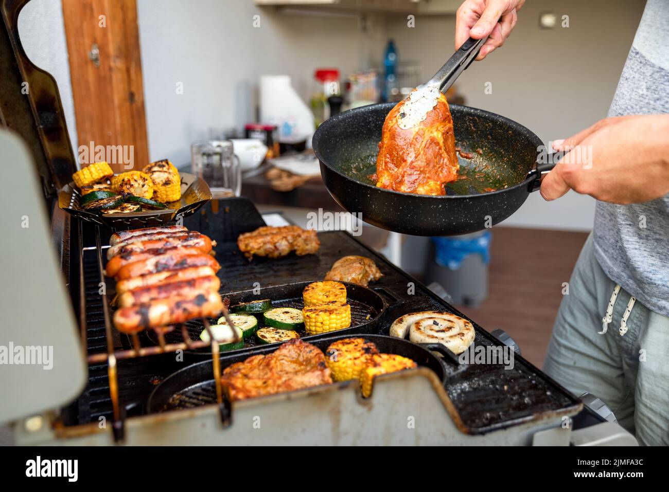 man is making grill barbecue outdoors on the backyard. Bbq party. Stock Photo