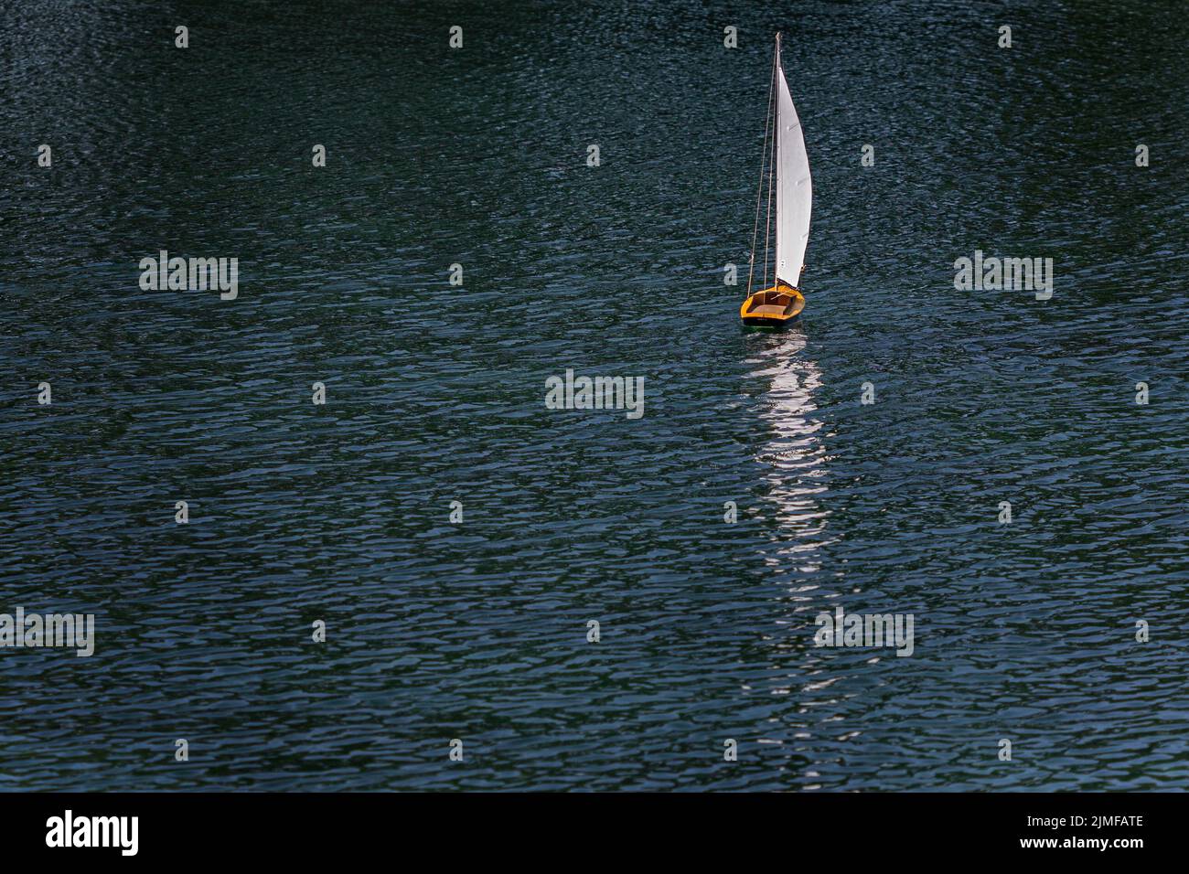 remote-controlled model boat being sailed on a pond in Littlehampton, West Sussex, UK Stock Photo