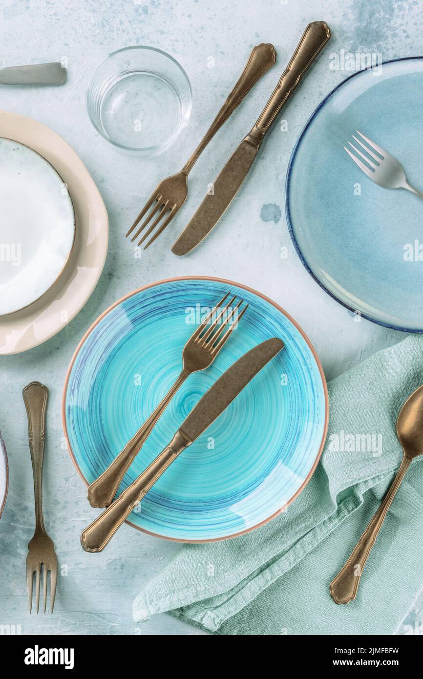 Blue plate and other tableware, shot from above on a table Stock Photo