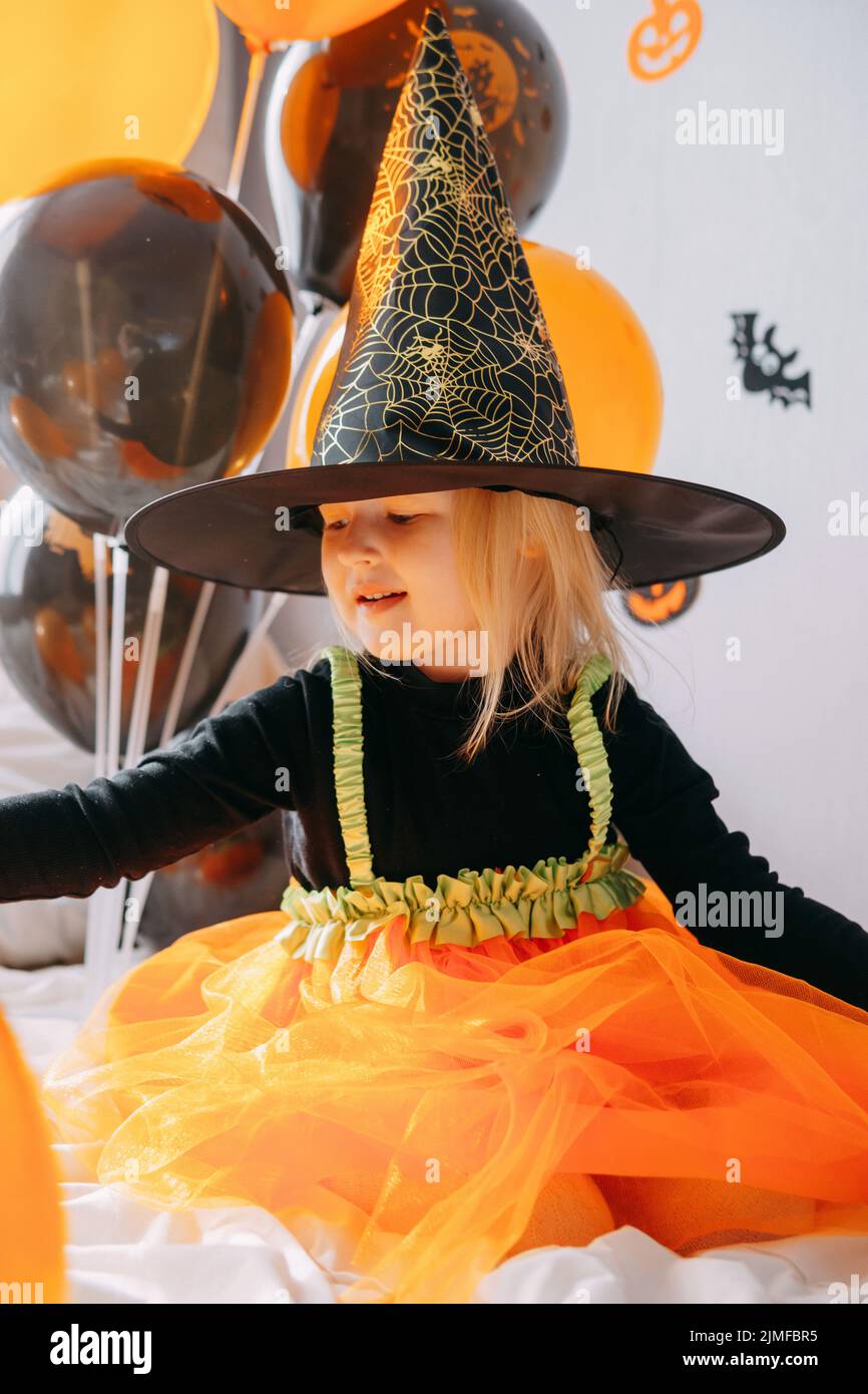 Children's Halloween a girl in a witch hat and a carnival costume