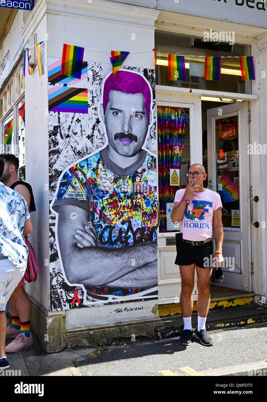 Brighton UK 6th August 2022 - A picture of the late Freddie Mercury watches as thousands take part in the  Brighton and Hove Pride Parade on a beautiful hot sunny day. With good weather forecast large crowds are expected to attend the UK's biggest LGBTQ Pride festival in Brighton over the weekend : Credit Simon Dack / Alamy Live News Stock Photo